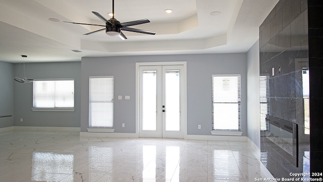 spare room with french doors, ceiling fan, and a raised ceiling