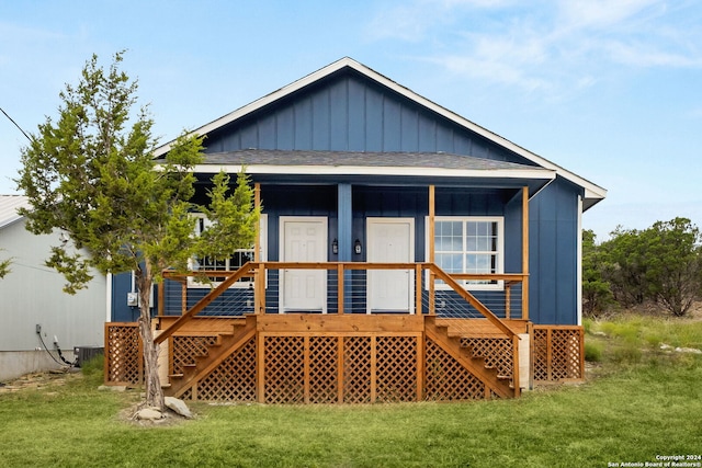 back of house featuring a yard and central air condition unit