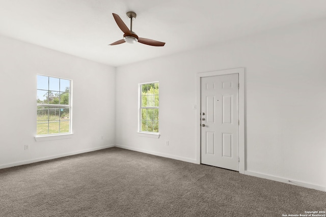 carpeted empty room featuring ceiling fan and plenty of natural light