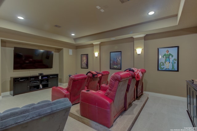 home theater featuring a raised ceiling, decorative columns, and light carpet