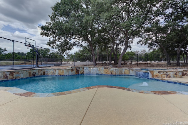 view of pool with pool water feature and a patio