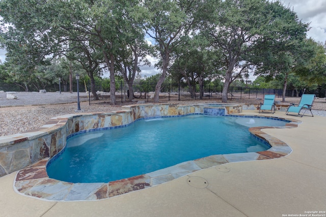 view of pool featuring a patio and an in ground hot tub