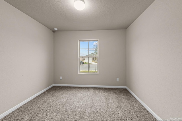 carpeted empty room featuring a textured ceiling