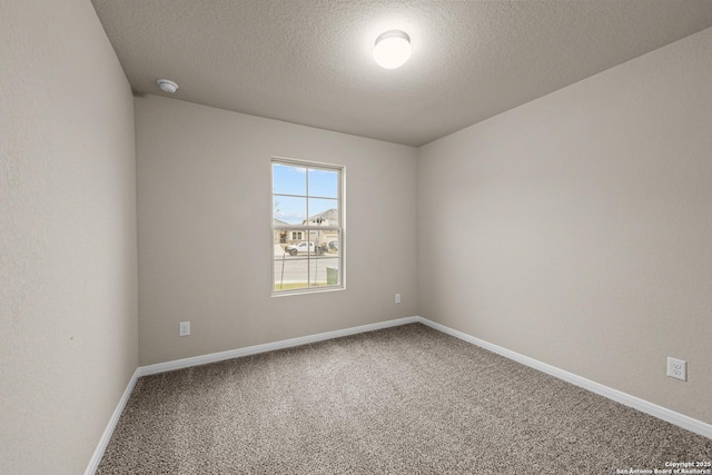 carpeted spare room featuring a textured ceiling