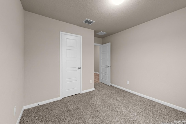 unfurnished bedroom with carpet floors and a textured ceiling