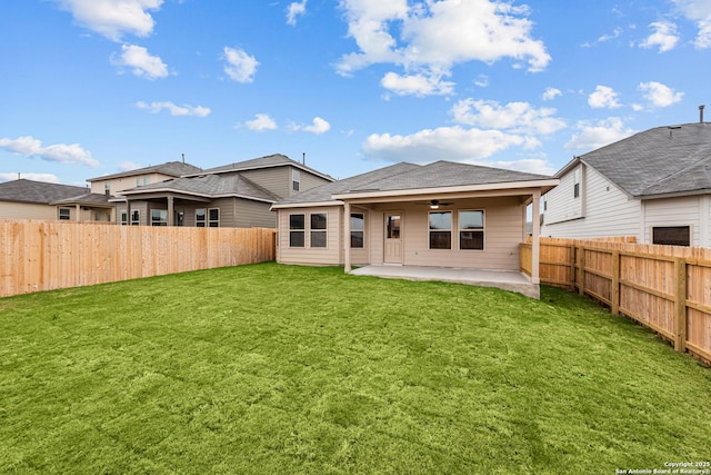 back of property with a yard, a patio, and ceiling fan