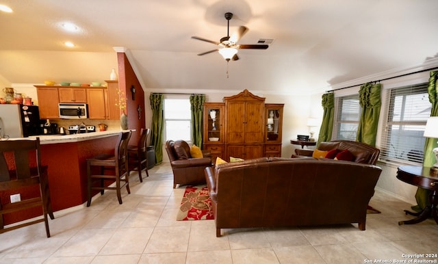 living room featuring a healthy amount of sunlight, light tile patterned floors, crown molding, and ceiling fan