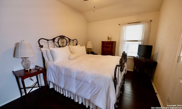 bedroom featuring vaulted ceiling and dark wood-type flooring