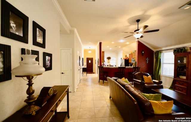 living room featuring ornamental molding, lofted ceiling, ceiling fan, and light tile patterned floors