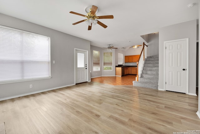 unfurnished living room featuring light hardwood / wood-style flooring, ceiling fan, and sink