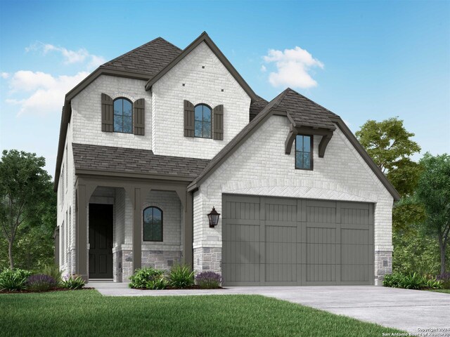 french country inspired facade featuring a front lawn and a garage