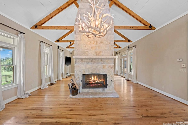 living room with a stone fireplace, beamed ceiling, light wood-type flooring, and high vaulted ceiling