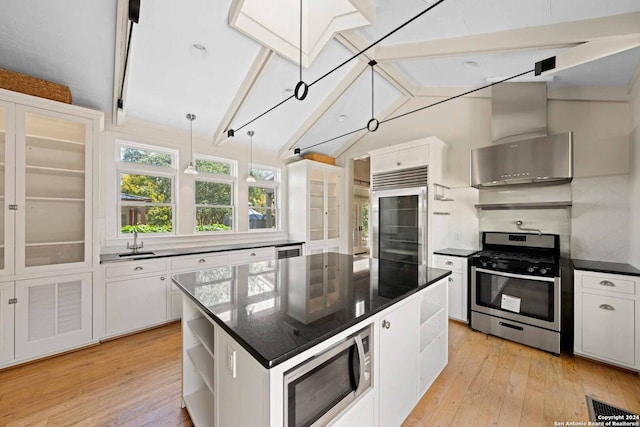 kitchen featuring light hardwood / wood-style floors, a kitchen island, built in appliances, and white cabinets