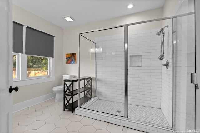 bathroom featuring a shower with shower door, toilet, and tile patterned flooring