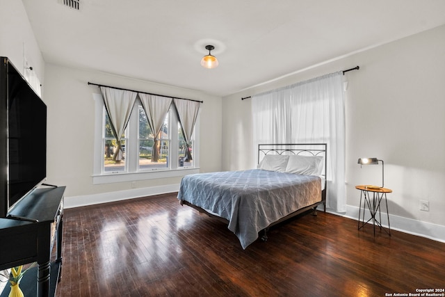 bedroom with dark hardwood / wood-style floors