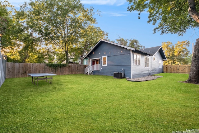 view of side of home with a lawn and cooling unit