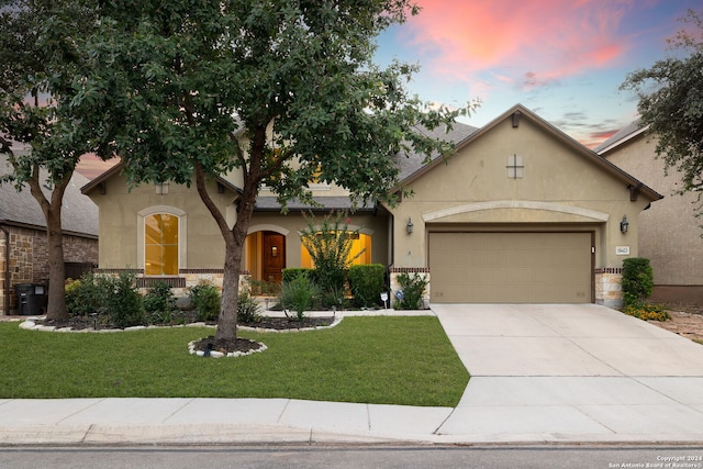 view of front of house with a garage and a lawn