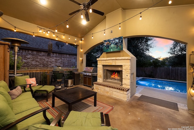 patio terrace at dusk with an outdoor living space with a fireplace, ceiling fan, a fenced in pool, and a grill