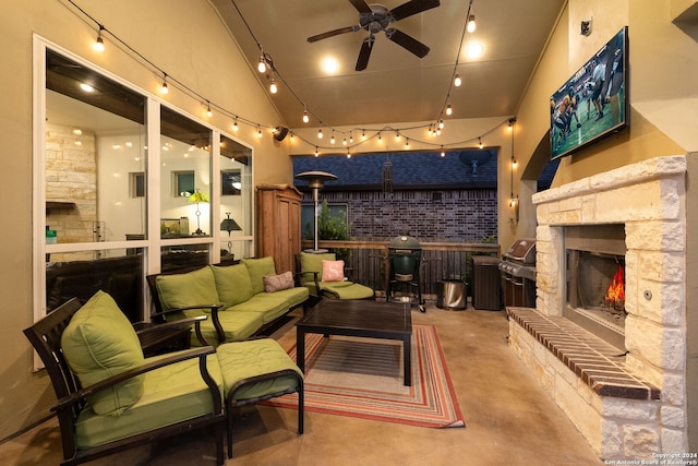 interior space featuring ceiling fan, a stone fireplace, and concrete flooring