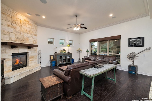 living room with dark hardwood / wood-style flooring, ceiling fan, a fireplace, and crown molding