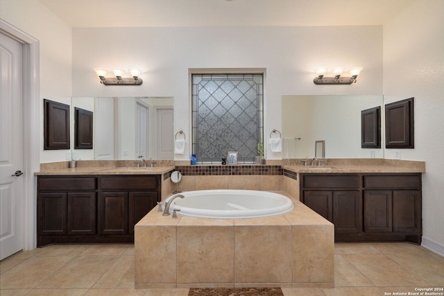 bathroom with tiled tub, vanity, and tile patterned floors