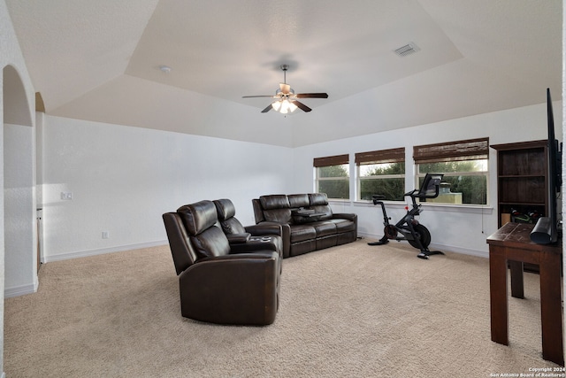 carpeted living room featuring a tray ceiling and ceiling fan