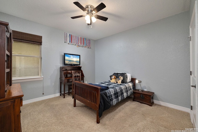 bedroom featuring a textured ceiling, ceiling fan, and light colored carpet