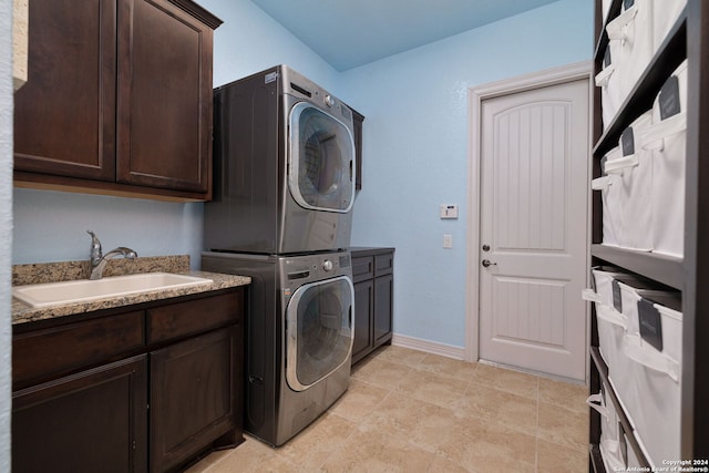 laundry area with stacked washing maching and dryer, sink, and cabinets