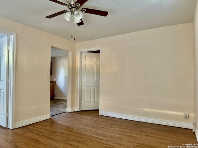 unfurnished room with dark hardwood / wood-style flooring and ceiling fan