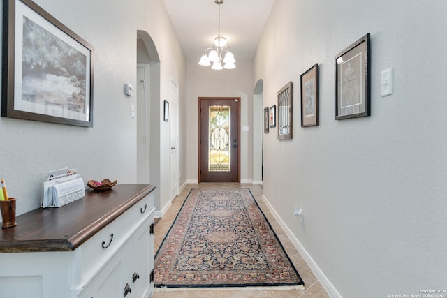 entryway featuring light tile patterned floors and a notable chandelier