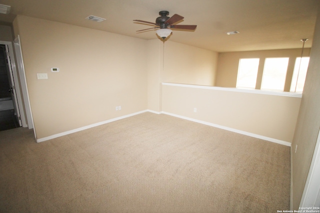 carpeted spare room featuring ceiling fan