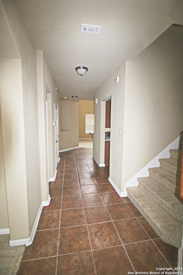 hallway with dark tile patterned floors