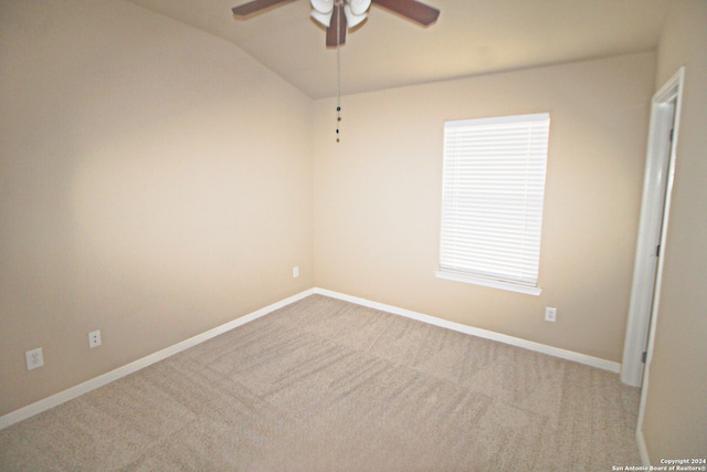 unfurnished room featuring ceiling fan, light colored carpet, and vaulted ceiling