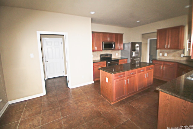 kitchen with backsplash, dark stone countertops, a kitchen island, and stainless steel appliances