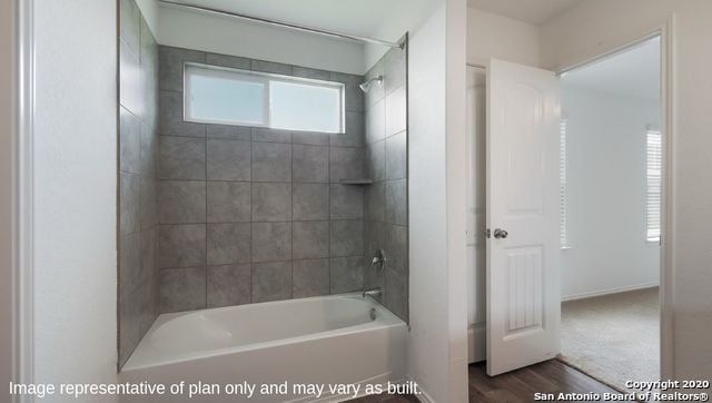 bathroom featuring wood-type flooring and tiled shower / bath combo