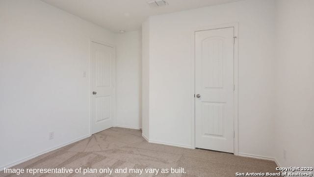 unfurnished bedroom featuring light carpet and a closet