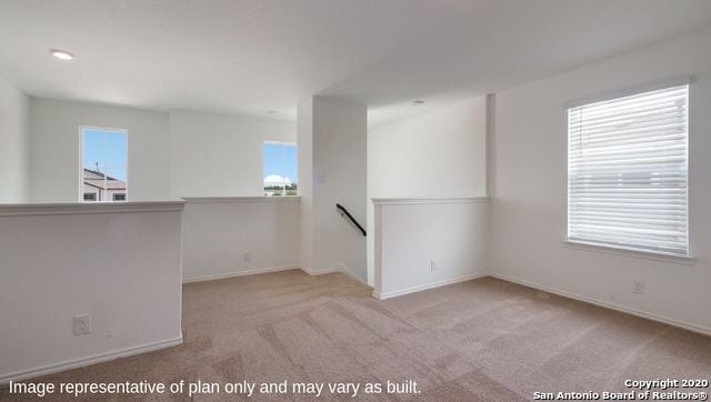 empty room featuring light carpet and a wealth of natural light