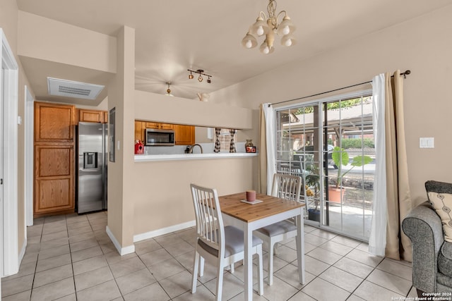 dining area featuring an inviting chandelier and light tile patterned flooring