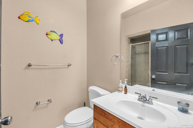 bathroom featuring vanity, toilet, and a shower with door