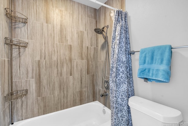 bathroom featuring shower / tub combo and toilet