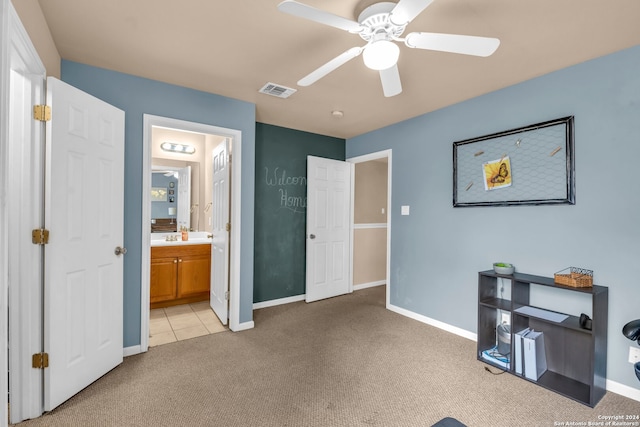 bedroom featuring ceiling fan, light carpet, and ensuite bathroom