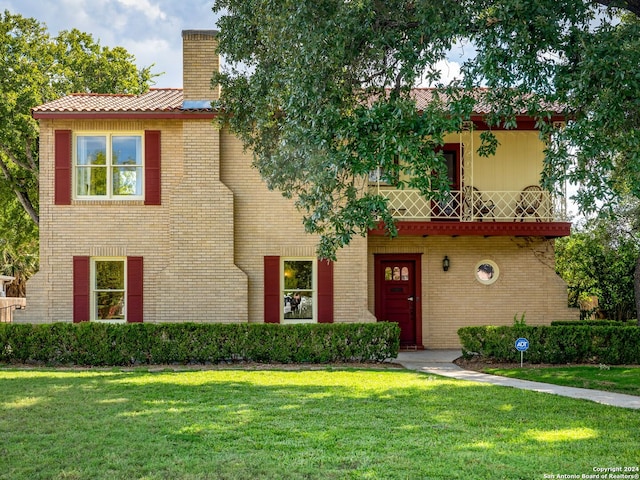 mediterranean / spanish home with a balcony and a front yard