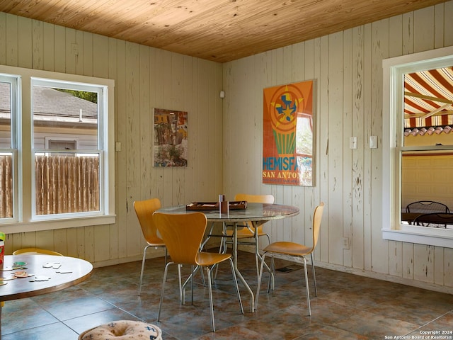 tiled dining area with wooden ceiling and wood walls