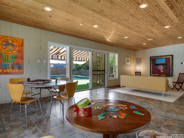 tiled dining room with wood walls and wooden ceiling