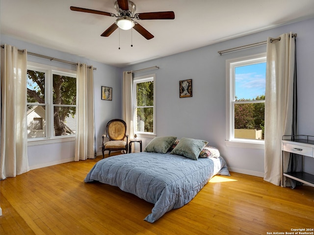 bedroom with light hardwood / wood-style floors and multiple windows