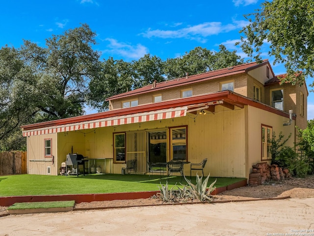 back of property with a yard and a patio area