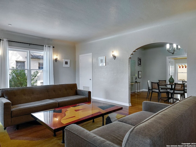 living room featuring a textured ceiling, an inviting chandelier, and dark hardwood / wood-style flooring