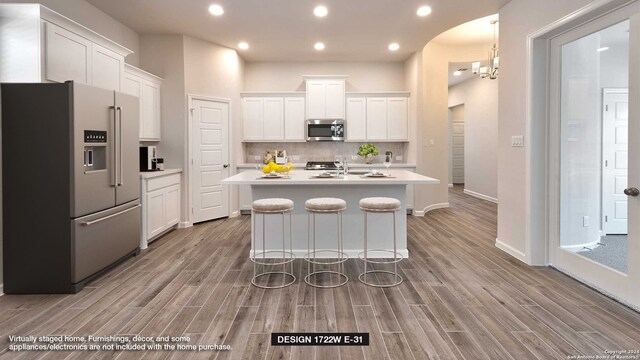 kitchen featuring appliances with stainless steel finishes, light wood-type flooring, and white cabinetry