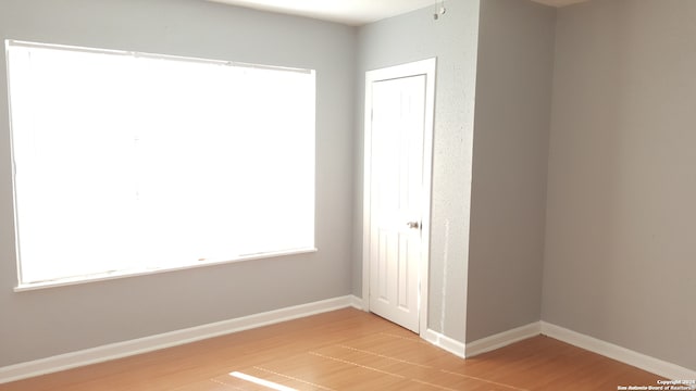 spare room featuring plenty of natural light and hardwood / wood-style floors