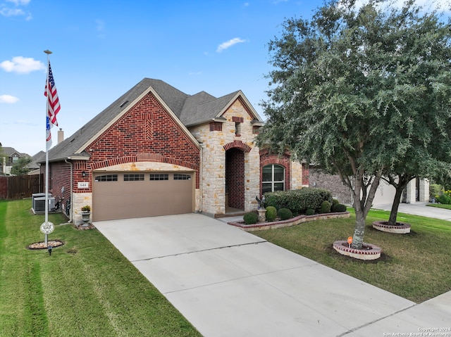 view of front of property with a front lawn, a garage, and central AC unit